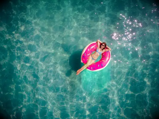Girl in donut float in swimming pool
