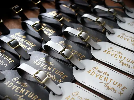 Travel-themed bridal shower invitations in the shape of luggage tags