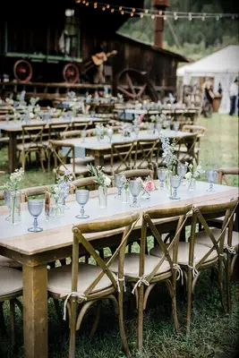 Wood Table With Simple Blue Runner, Goblets and Flowers at Rustic Rehearsal Dinner