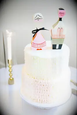 Textured engagement cake featuring quirky cake topper of the couple
