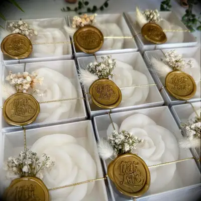 White rose candles in packages with a gold wax stamp
