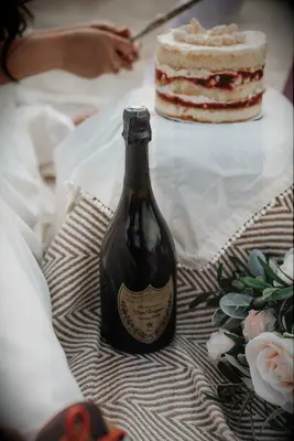 Bottle of Don beside a sponge cake at a bridal shower picnic