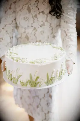 Simple white cake with lily of the valley decorations