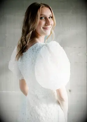 Bride wearing white puff sleeve dress at Bridgerton themed bridal shower