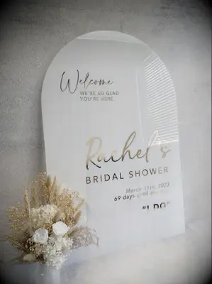 White arch welcome engagement sign with gold lettering for boho bridal shower
