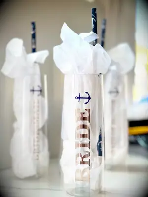 Clear champagne flute with rose gold type and navy blue anchor