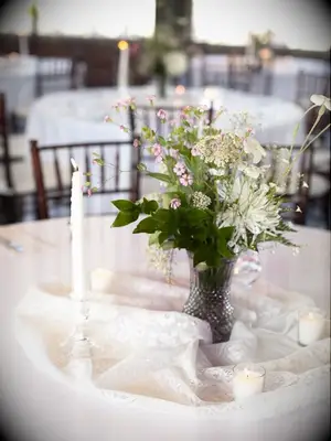 A delicate and lovely centerpiece of wildflowers and greenery.