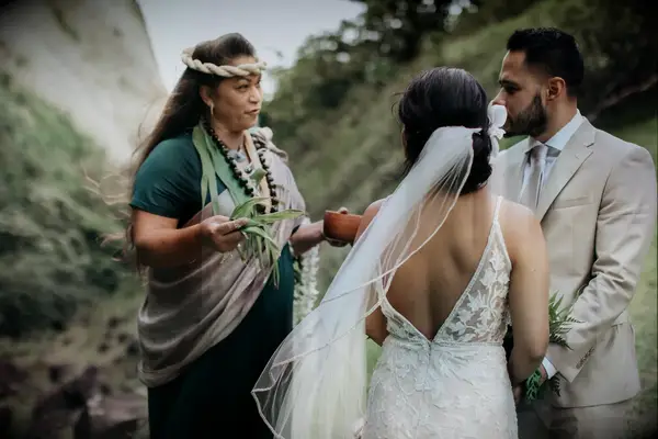 Wedding officiant guiding couple through traditional Hawaiian wedding ceremony