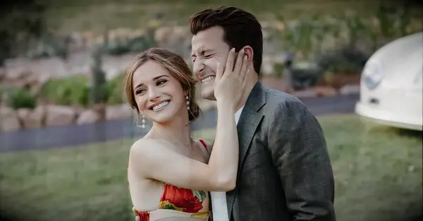 how to plan a rehearsal dinner; couple smiling at wedding rehearsal dinner