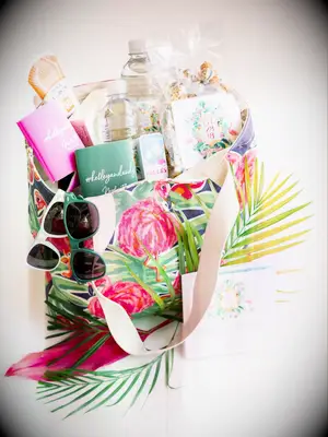 beach wedding welcome bag with sunglasses, bottled water, sunscreen, drink koozies and snacks