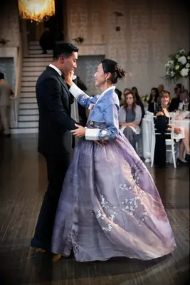 Mother dancing with groom at wedding in traditional Korean hanbok