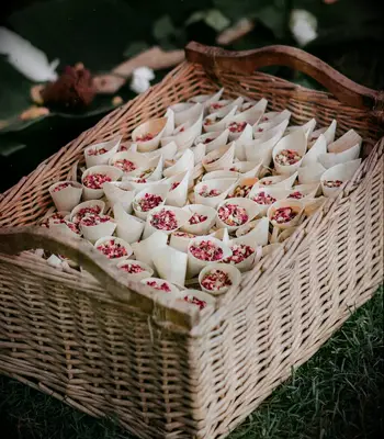 Basket full of dried rose petal confetti cones