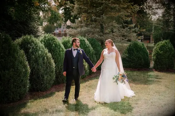 Bride and groom holding hands at outdoor wedding venue