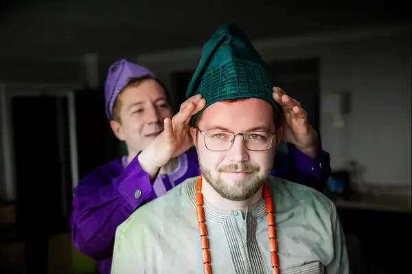 Groom Getting Teal Yoruba Fila Head Cap Pit on Before Nigerian Wedding