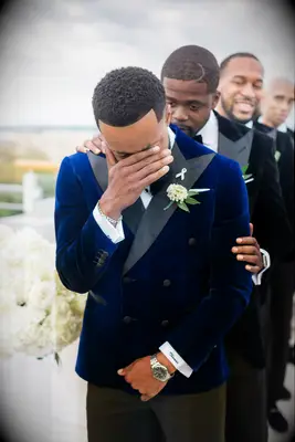 Best man comforting groom crying at altar