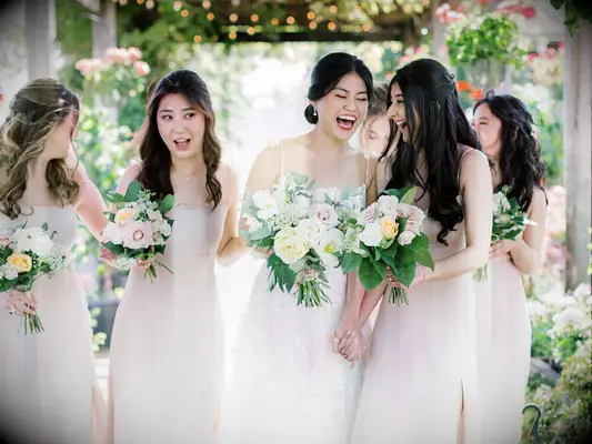 Bride and bridesmaids laughing together.