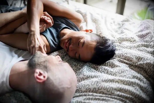 Two men cuddle among the covers