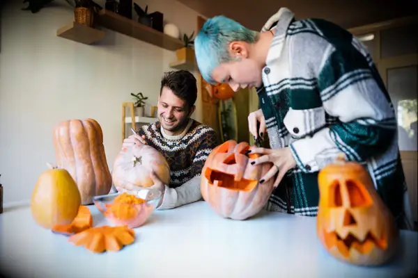 Couple carving pumpkins together