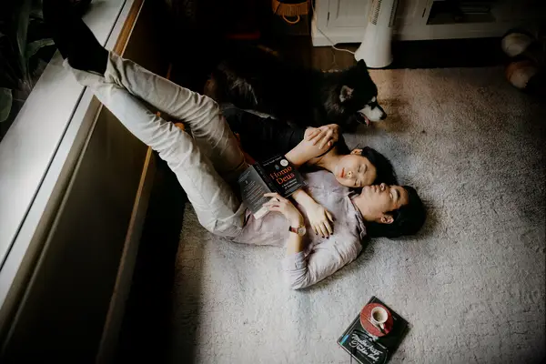 Cute Couple Poses: Couple cuddles on the floor with their dog next to them. 