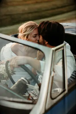 Couple Poses: Couple shares a sweet kiss in a retro car. 