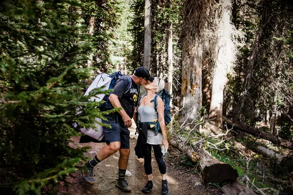 Cute Couple Poses: Couple on a hike pauses to share a sweet kiss. 