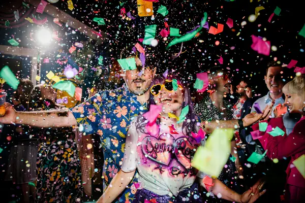 Cute Couple Poses: Couple dances while confetti falls around them. 