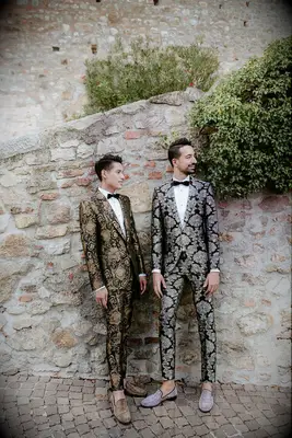 Cute Couple Poses: Couple stares off into the distance while wearing chic suits. 