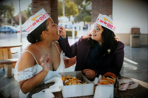 Cute Couple Poses: Couple feeds each other french fries outside an In-N-Out. 