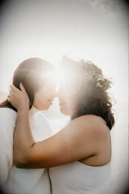 Cute Couple Poses: Couple embraces while the sun shines in the background. 