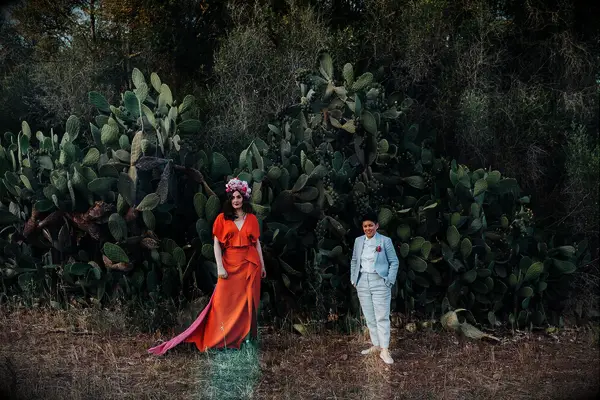 Couple Poses: Couple poses in front of a large cactus. 