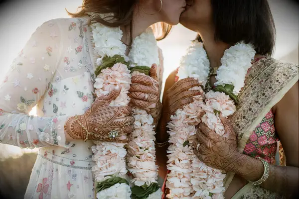 Cute Couple Poses: Couple kiss while wearing beautiful leis. 