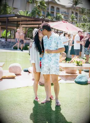 Couple Poses: Couple kiss at an outdoor party. 