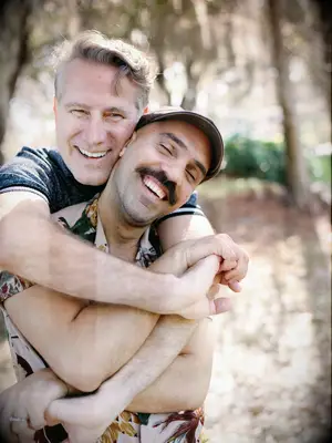 Cute Couple Poses: Couple smile while embracing in a hug. 