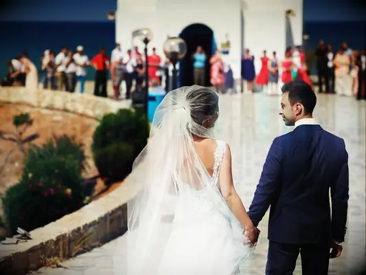 Couple outside the church on the day of their wedding on the island of Santorini, Greece
