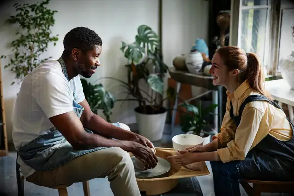 An interracial couple bond over a pottery class