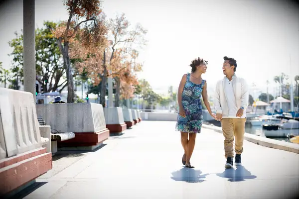 A mixed race couple enjoy a sunny afternoon walk