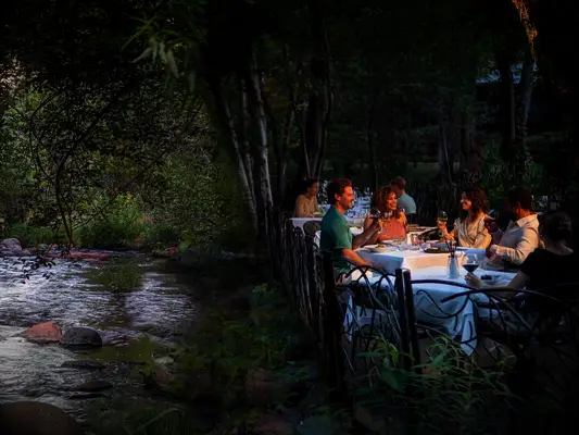 Group having dinner on patio by river