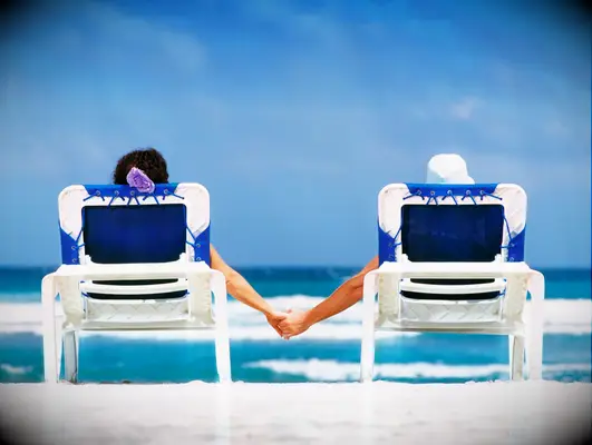 st croix couple lounges on beach chairs and holds hands