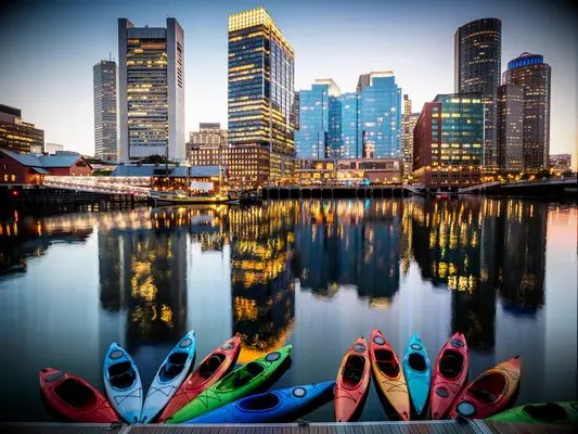 Kayaks on lake looking out across Boston skyscrapers