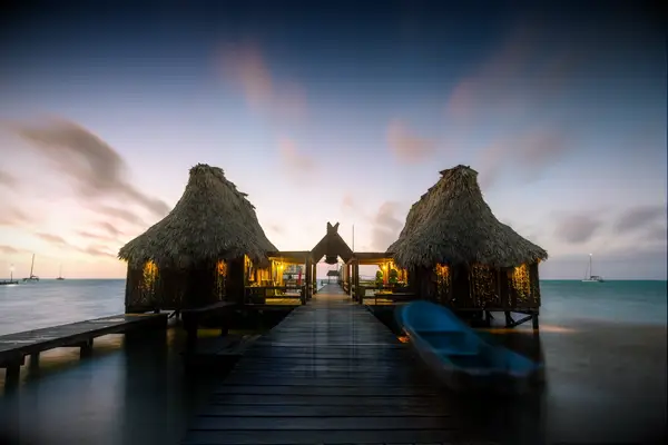 Overwater bungalow and jetty at sunset, Belize