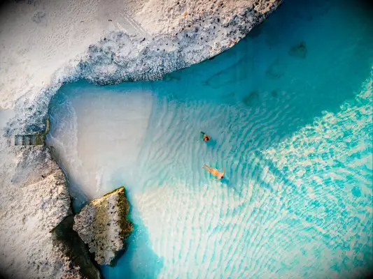 A couple in clear waters on a beach in Aruba