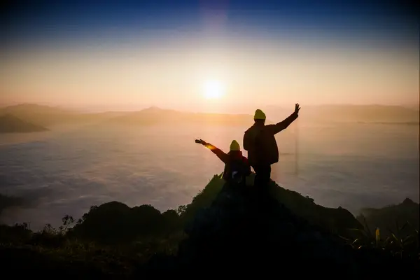 Couple posing on peak of mountain